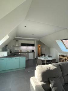 a living room with a couch and a kitchen at LE BRIDGE in Bénouville