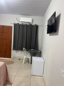 a room with a bed and a table and a television at Hotel Colinas in Cajuapara