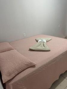 a bed with a blanket and a towel on it at Hotel Colinas in Cajuapara