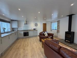 a large living room with a couch and a kitchen at Pendragon Studio in Penzance