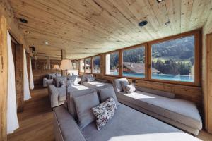 ein Zimmer mit Sofas und Fenstern in einem Haus in der Unterkunft Genusshotel Vermala Montafon in Sankt Gallenkirch