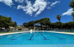 a large swimming pool with a blue sky in the background at La casa del pinsapo in Yunquera