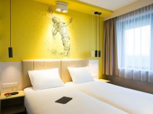 a bedroom with a bed and a painting on the wall at ibis Styles Haarlem City in Haarlem +49 photos