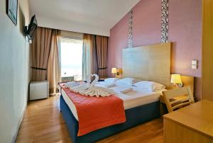 a hotel room with a bed with a swan on it at Sandy Bay Hotel in Plomari +47 photos