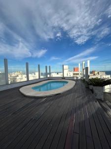 a small pool on a deck with a view of a city at MySuites in Montevideo