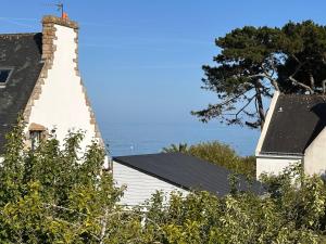 a lighthouse in front of a house with the ocean in the background at Le Clos Ker'hadenn, chambres d'hôtes à Saint-Pierre Quiberon, à deux pas de la plage in Saint-Pierre-Quiberon +18 photos