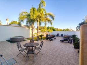 a patio with tables and chairs and palm trees at Villa Turicchio in Taranto