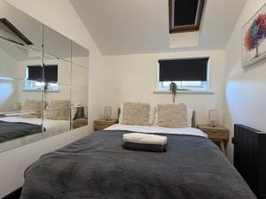 a bedroom with a large bed and two windows at Glowstay 2 in Lampeter