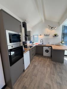 a kitchen with white appliances and a wooden floor at Glowstay 2 in Lampeter