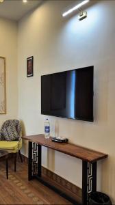 a living room with a table and a television on a wall at JAANI's Hotel in Bhattiawāla
