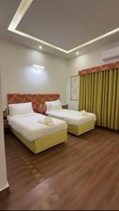 two beds in a hotel room with at JAANI's Hotel in Bhattiawāla
