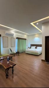 a large room with a bed and a couch and a table at JAANI's Hotel in Bhattiawāla