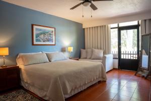 a bedroom with a large bed and a chair at Toca Madera in Chapala