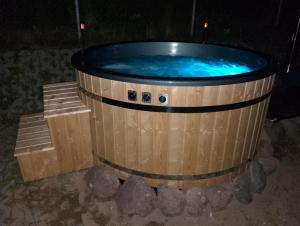 a hot tub in a wooden barrel at night at Apartament Harsz in Harsz