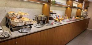a buffet line with bread and baskets of food at Coral Express próximo ao Parque Harmonia e Beira Rio in Porto Alegre