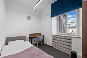 a bedroom with a bed and a desk and a window at ZDZ Hostel Królewska 15 in Lublin +27 photos