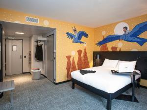a bedroom with a bed with blue birds on the wall at ibis Styles Genève Carouge in Geneva +114 photos
