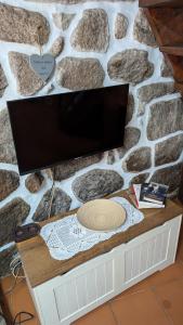 a flat screen tv sitting on top of a stone wall at Casa D'Zelo - Gerês in Montalegre