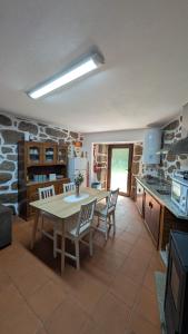 a kitchen with a table and chairs in a room at Casa D'Zelo - Gerês in Montalegre