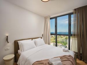 a bedroom with a bed and a large window at NS Luxury Villas in Podstrana +78 photos
