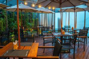 a restaurant with wooden tables and chairs and umbrellas at Holiday Inn Belo Horizonte Savassi by IHG in Belo Horizonte