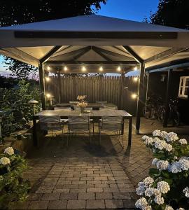 a table and chairs under a gazebo with lights at Lolland Bed & Breakfast in Søllested