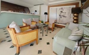 a living room with a couch and chairs and a table at Sandy Bay Hotel in Plomari