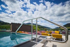 a house with a swimming pool with mountains in the background at nōa Schladming in Schladming