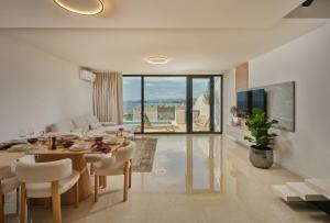 a living room with a table and chairs and a television at NS Luxury Villas in Podstrana
