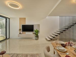 a living room with a dining table and a tv at NS Luxury Villas in Podstrana