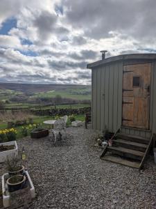 a small shed with a bench and a table at Shepherd's Hut Bilsdale in Chop Gate