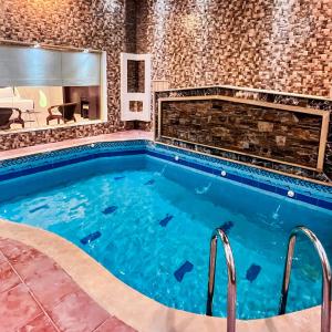 a swimming pool in a room with a brick wall at فلل أرياف - Aryaf in Abha