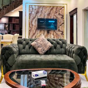 a living room with a couch and a tv on a wall at فلل أرياف - Aryaf in Abha