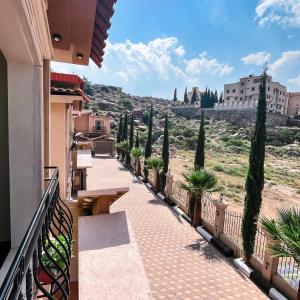 a balcony with a view of a hill with trees at فلل أرياف - Aryaf in Abha