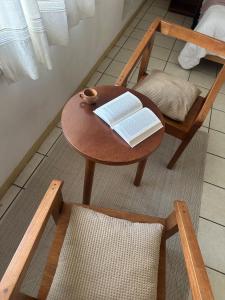 a wooden table with a book and a chair at Casa Ritual tu refugio con jardín & 4 recámaras in Oaxaca City