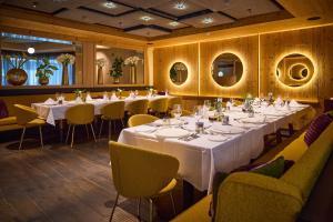 a dining room with white tables and yellow chairs at nōa Schladming in Schladming