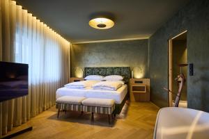 a bedroom with a large bed and a television at nōa Schladming in Schladming +184 photos