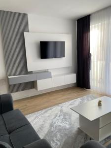 a living room with a tv on a white wall at Adora's Apartment in Peje