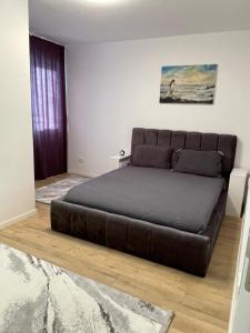 a large bed in a room with a couch at Adora's Apartment in Peje
