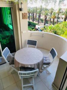 a table and chairs on a balcony with palm trees at The hidden oasis, steps from the beach and pool in Mohammedia