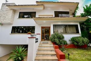 a house with a staircase in front of it at Casa Ritual tu refugio con jardín & 4 recámaras in Oaxaca City