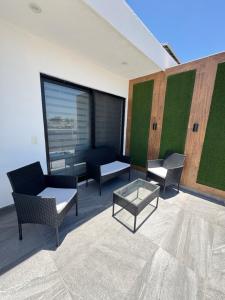 a patio with chairs and a table and a couch at Loft with Private Terrace in Tepic +4 photos