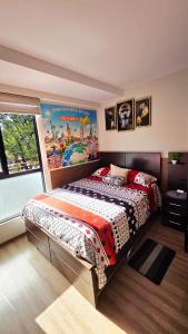 a bedroom with a bed with a poster on the wall at Apartamento EL PRADO de lujo in Cochabamba +19 photos