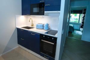 a kitchen with blue cabinets and a sink and a stove at Opera Magic Castle View, Air-Con, Free wifi in Savonlinna