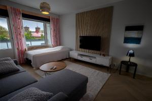 a living room with two beds and a television at Opera Magic Castle View, Air-Con, Free wifi in Savonlinna
