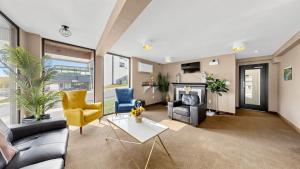 ein Wohnzimmer mit Sofa, Sesseln und Kamin in der Unterkunft River Rapids Inn in Niagara Falls