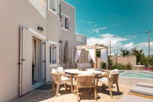 a patio with a table and chairs and a pool at Selenophile Villa with heated pool in Monolithos