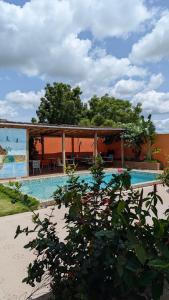 a swimming pool with a pavilion next to a house at Résidences AMAN in Morofé