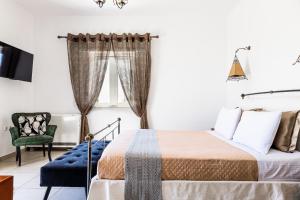 a bedroom with a bed and a chair at Selenophile Villa with heated pool in Monolithos +63 photos