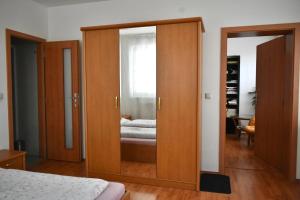 a bedroom with a large wooden cabinet with a mirror at Villa Paris in Piešťany